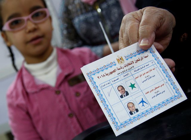 Una mujer egipcia muestra su papeleta con letrero para el presidente egipcio Abdel Fattah al-Sisi antes de emitir su voto durante el primer día de las elecciones presidenciales en un colegio electoral en El Cairo, Egipto, el 26 de marzo de 2018. REUTERS / Amr Abdallah Dalsh