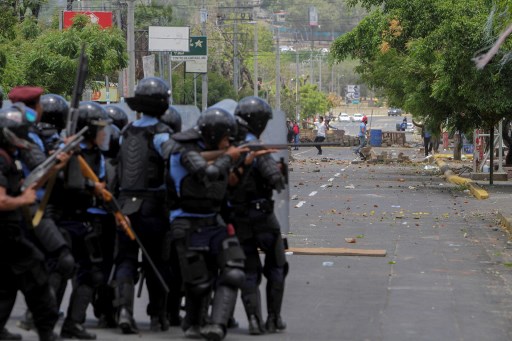 Agentes de la policía antidisturbios chocan con estudiantes frente a la Universidad de Ingeniería durante una protesta contra las reformas del gobierno en el Instituto de Seguridad Social (INSS) en Managua el 20 de abril de 2018. Un manifestante y un policía fueron asesinados en la capital nicaragüense Managua después de las manifestaciones La reforma de las pensiones se tornó violenta la noche del jueves, dijeron las autoridades. Las muertes se produjeron después de las protestas de opositores y partidarios de una nueva ley, que aumenta las contribuciones de los empleadores y los empleados, mientras que reduce el monto total de las pensiones en un cinco por ciento, sacudió la capital por segundo día consecutivo.