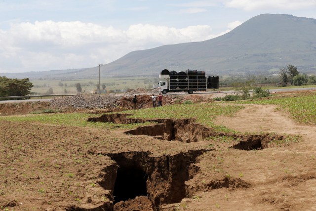 A truck drives near a chasm suspected to have been caused by a heavy downpour along an underground fault-line near the Rift Valley town of Mai Mahiu, Kenya March 28, 2018. Picture taken March 28, 2018. REUTERS/Thomas Mukoya