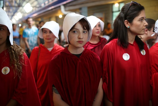 Activists dressed in costumes from The Handmaid's Tale series wait for the presidential candidate Carlos Alvarado Quesada at a polling station in San Jose, Costa Rica on April 1, 2018. REUTERS/Jose Cabezas