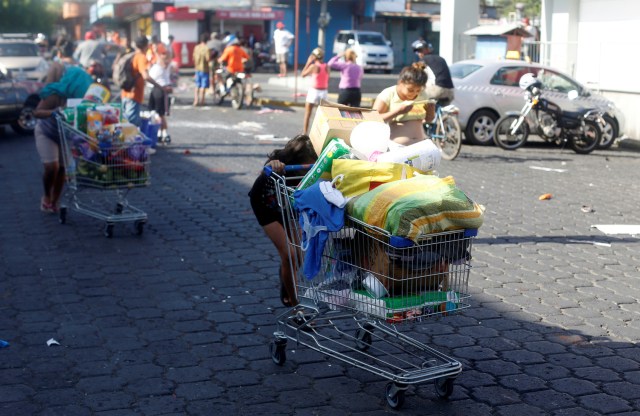 Gente se lleva mercadería saqueada de un supermercado en carritos por las calles después de protestas contra una controvertida reforma del sistema de pensiones en Managua, Nicaragua, abril 22, 2018. REUTERS/Jorge Cabrera - RC1EF7175E60