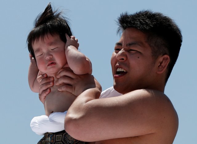 Un bebé llora en los brazos de un peleador de zumo amateur |FOTO: REUTERS/Issei Kato