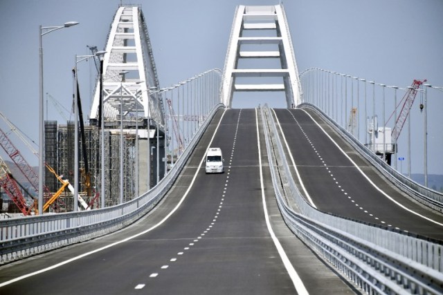 Un vehículo recorre el Puente de Crimea, de 19 km de longitud, cruzando el estrecho de Kerch y uniendo el sur de Rusia con la península de Crimea el 15 de mayo de 2018 en Kerch, antes de la ceremonia de apertura. El presidente ruso, el 15 de mayo, inaugurará un puente de 19 kilómetros que unirá el sur de Rusia con la península de Crimea anexada desde Ucrania, un proyecto altamente simbólico que ha defendido personalmente. Construida a un costo de 228 mil millones de rublos ($ 3,69 mil millones), la nueva estructura conecta la región del sur de Krasnodar con la ciudad de Crimea de Kerch, que abarca un estrecho entre el Mar Negro y el Mar de Azov. / AFP PHOTO / POOL / Alexander NEMENOV