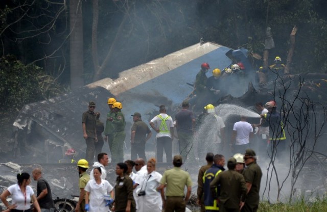 Emergency personnel work at the site of the accident after a Cubana de Aviacion aircraft crashed after taking off from Havana's Jose Marti airport on May 18, 2018. A Cuban state airways passenger plane with 113 people on board crashed on shortly after taking off from Havana's airport, state media reported. The Boeing 737 operated by Cubana de Aviacion crashed "near the international airport," state agency Prensa Latina reported. Airport sources said the jetliner was heading from the capital to the eastern city of Holguin.  / AFP PHOTO / Yamil LAGE