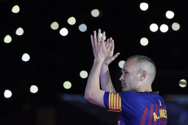 El centrocampista español del Barcelona, Andrés Iniesta, reconoce a los aficionados durante un homenaje al final del partido de fútbol de la liga española entre el FC Barcelona y la Real Sociedad en el estadio Camp Nou de Barcelona el 20 de mayo de 2018. Iniesta, quien se unió a la academia de Barcelona hace 22 años, jugó su último partido para el club. / AFP PHOTO / LLUIS GENE