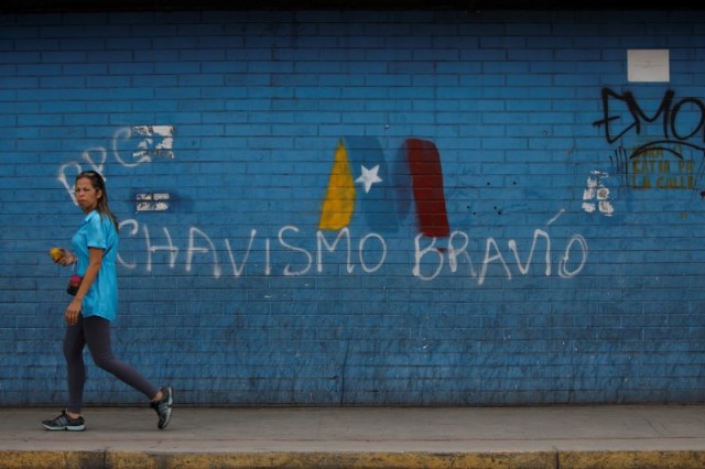 Una mujer pasa frente a un graffiti de campaña a favor del presidente de Venezuela, Nicolás Maduro, en Caracas. Mayo 8, 2018. REUTERS/Adriana Loureiro