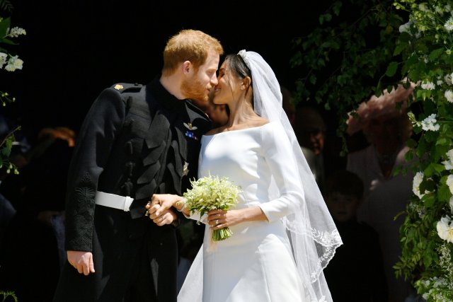 Prince Harry and Meghan Markle kiss on the steps of St George's Chapel in Windsor Castle after their wedding in Windsor, Britain, May 19, 2018. Ben Birchall/Pool via REUTERS