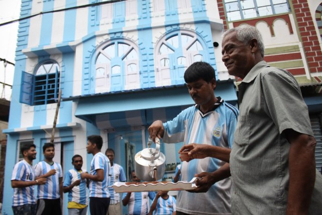 Shib Shankar Patra (2R), aficionado al fútbol del equipo argentino, sirve té a los fanáticos y clientes en frente de su departamento pintado en azul y blanco, antes de la próxima Copa Mundial 2018, el 11 de junio de 2018. Un juego duro El aficionado argentino en India ha pintado su casa con los colores azul y blanco del equipo antes de la Copa del Mundo, diciendo que su amor por los hombres de Lionel Messi no tiene límites. La pasión del residente de Kolkata Shib Shankar Patra por Argentina comenzó durante el Mundial de 1986 cuando Diego Maradona ayudó al equipo a ganar el codiciado trofeo. AFP